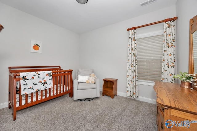 bedroom featuring carpet floors, baseboards, visible vents, and a crib