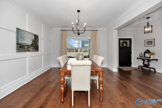 dining room featuring dark wood-type flooring, a decorative wall, ornamental molding, and an inviting chandelier