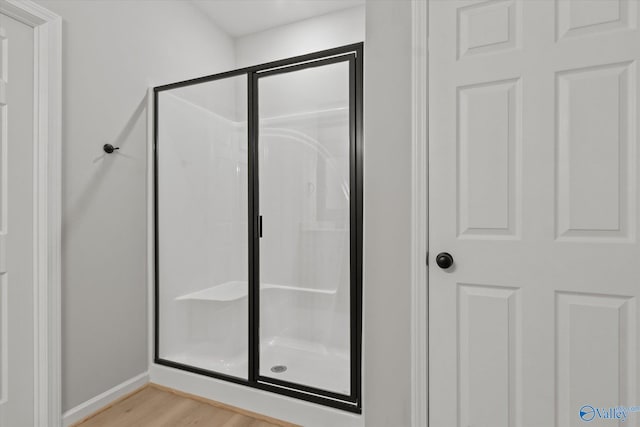 bathroom featuring a shower with door and hardwood / wood-style floors