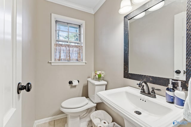 bathroom with tile patterned flooring, toilet, crown molding, and sink