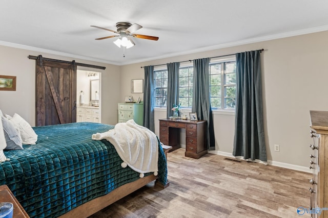 bedroom with ensuite bathroom, crown molding, ceiling fan, a barn door, and light wood-type flooring