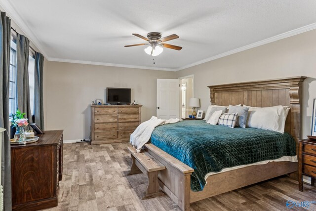 bedroom with ceiling fan, light hardwood / wood-style floors, and crown molding