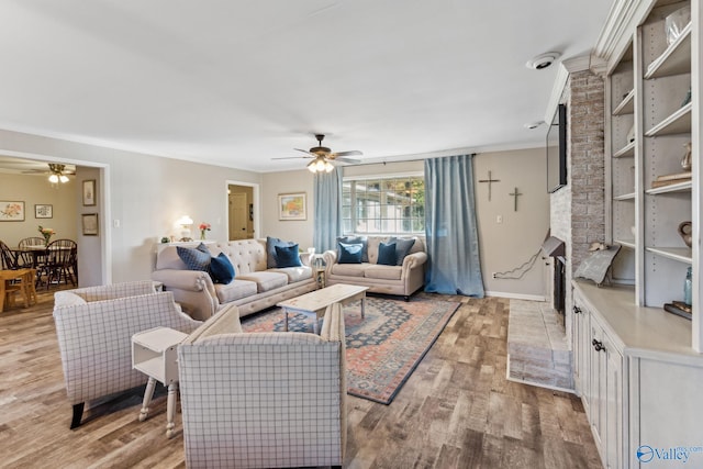 living room featuring light hardwood / wood-style floors, ceiling fan, and crown molding