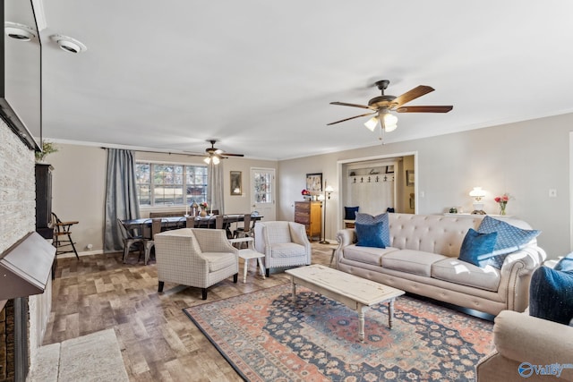 living room with crown molding, ceiling fan, and light wood-type flooring