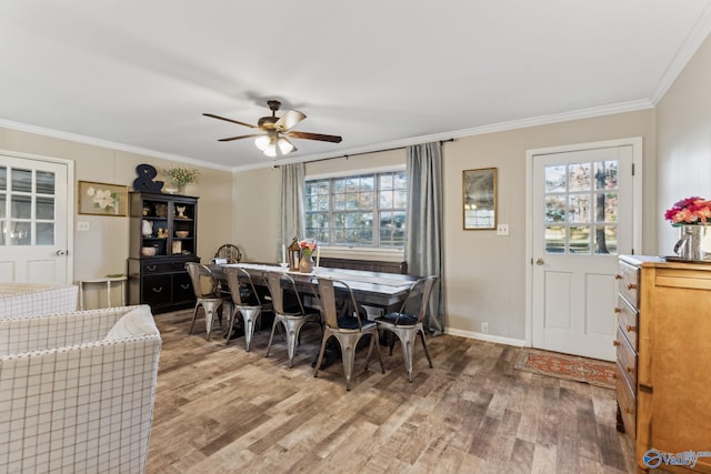 dining space with hardwood / wood-style floors, a wealth of natural light, and crown molding