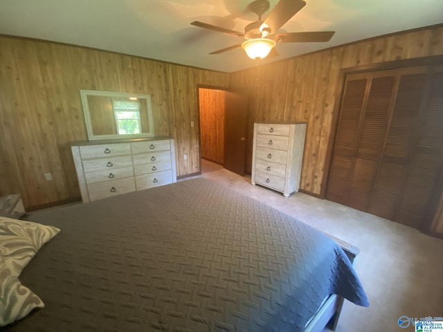 bedroom with carpet flooring, a closet, ceiling fan, and wood walls