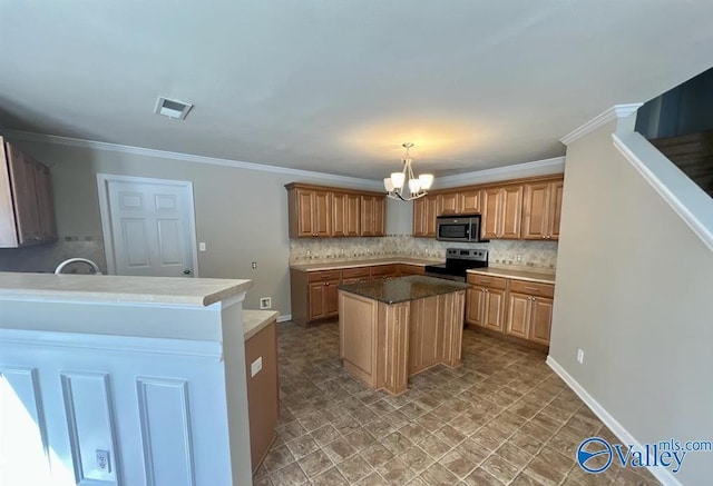 kitchen featuring pendant lighting, appliances with stainless steel finishes, an inviting chandelier, a center island, and decorative backsplash