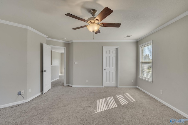 unfurnished bedroom featuring ornamental molding, light colored carpet, and ceiling fan