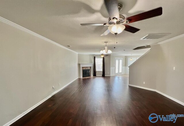 unfurnished living room with ornamental molding, ceiling fan with notable chandelier, and dark hardwood / wood-style flooring