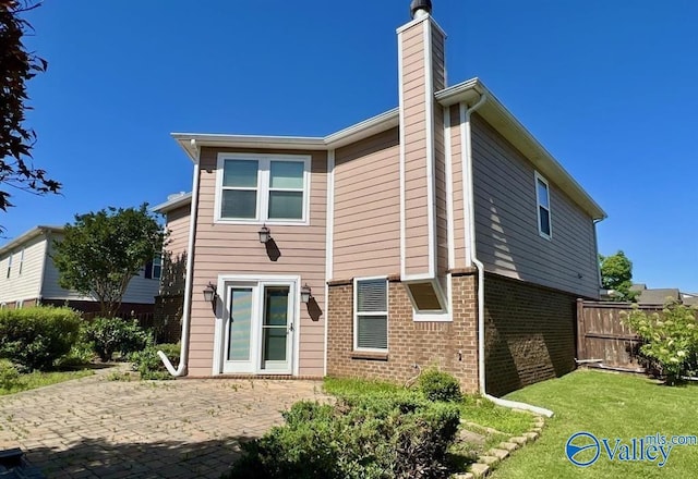 back of property with a yard and a patio area