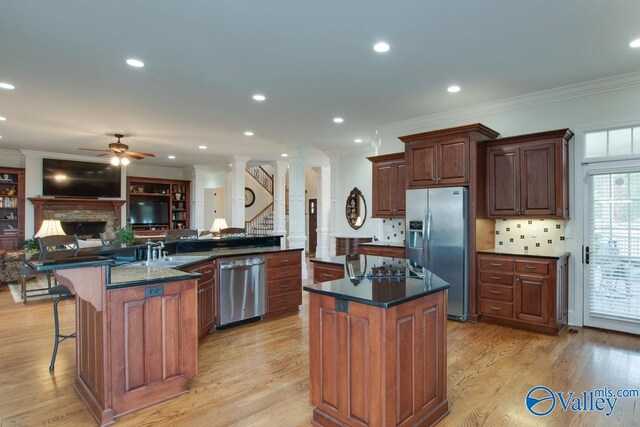 kitchen with appliances with stainless steel finishes, a large island, and light hardwood / wood-style floors