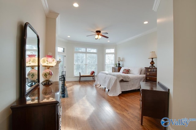 bedroom with ceiling fan, crown molding, and wood-type flooring