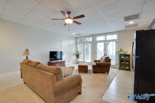 living room featuring a paneled ceiling, ceiling fan, and light carpet