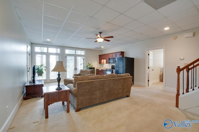 carpeted living room with a paneled ceiling and ceiling fan