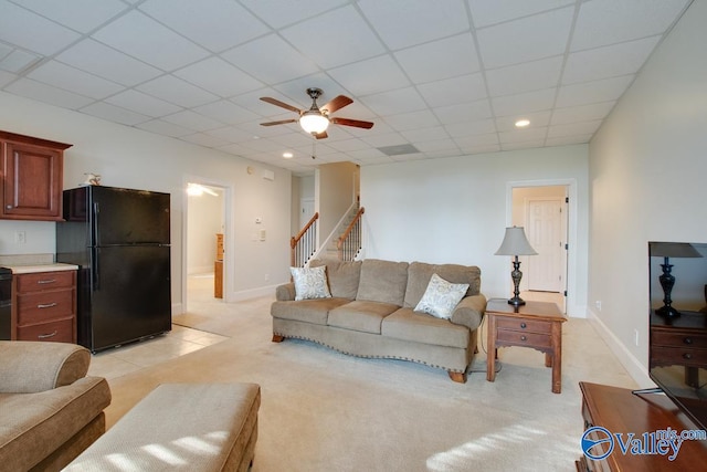 carpeted living room featuring a drop ceiling and ceiling fan