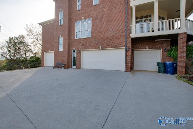 view of property exterior with a balcony and a garage