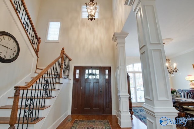 entryway with a towering ceiling, hardwood / wood-style flooring, and plenty of natural light