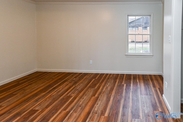 spare room with crown molding, wood finished floors, and baseboards