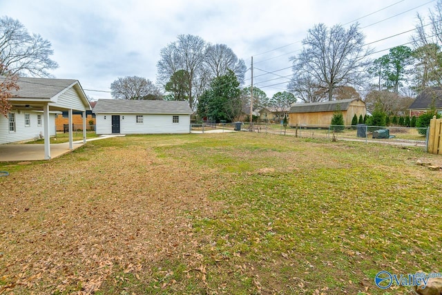 view of yard with a fenced backyard, an outdoor structure, and a patio