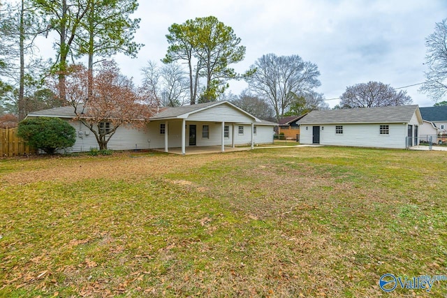 rear view of house featuring a yard, a patio, and fence