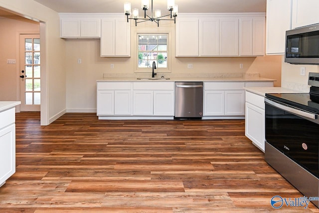 kitchen featuring white cabinets, stainless steel appliances, a sink, and light countertops