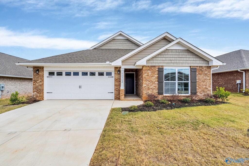 view of front of home with a front yard and a garage