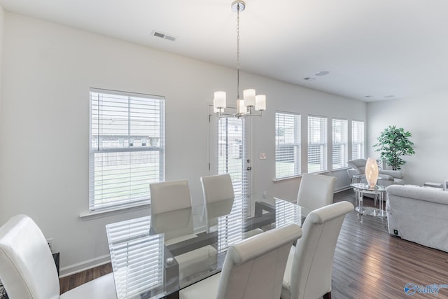 dining room with a chandelier, dark wood-type flooring, and a healthy amount of sunlight