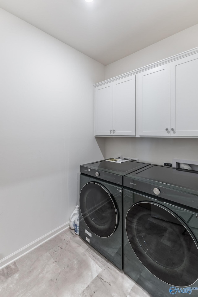 laundry area featuring cabinets and washing machine and clothes dryer