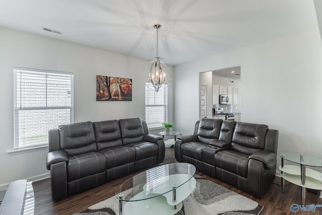 living room with an inviting chandelier and dark hardwood / wood-style floors