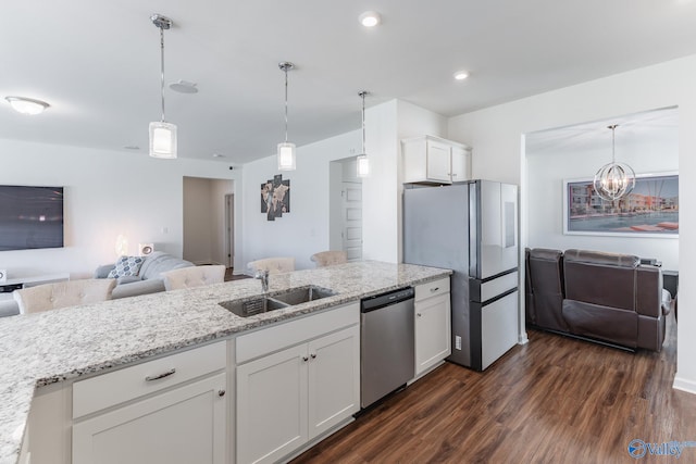 kitchen with light stone counters, pendant lighting, white cabinetry, stainless steel appliances, and dark hardwood / wood-style flooring