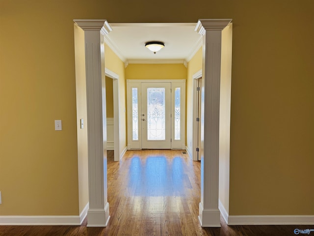 entryway with crown molding, decorative columns, and hardwood / wood-style floors