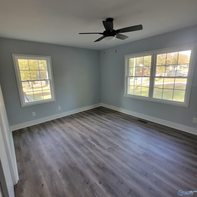 unfurnished room with ceiling fan and dark wood-type flooring