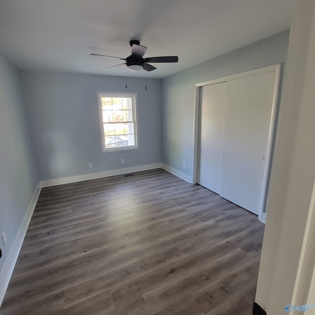 unfurnished bedroom with a closet, ceiling fan, and dark hardwood / wood-style flooring