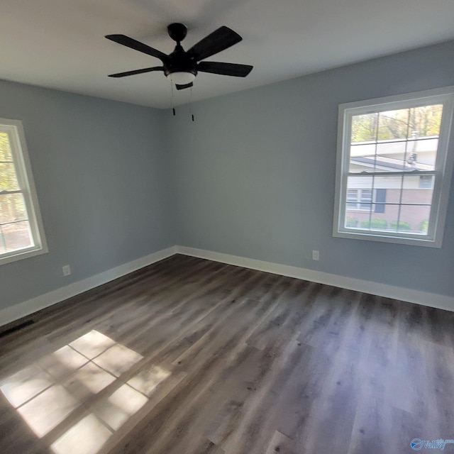 unfurnished room featuring ceiling fan and dark wood-type flooring