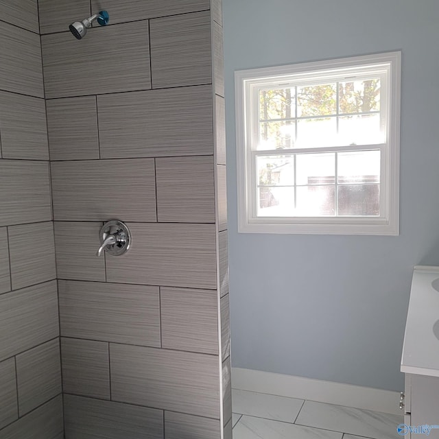 bathroom featuring a tile shower and vanity