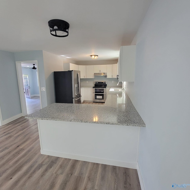 kitchen featuring light hardwood / wood-style floors, white cabinetry, kitchen peninsula, and appliances with stainless steel finishes