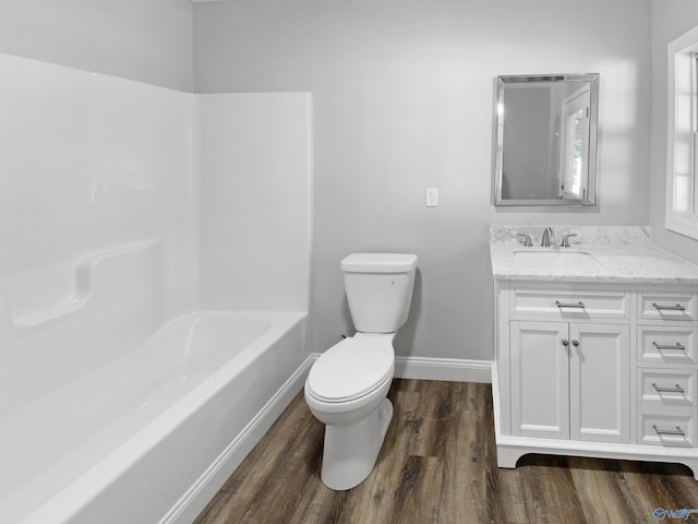 full bathroom featuring hardwood / wood-style flooring, shower / tub combination, vanity, and toilet