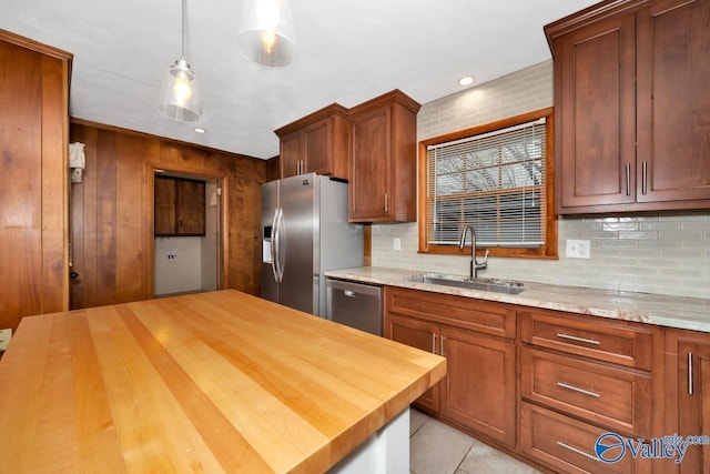 kitchen featuring pendant lighting, decorative backsplash, sink, and appliances with stainless steel finishes