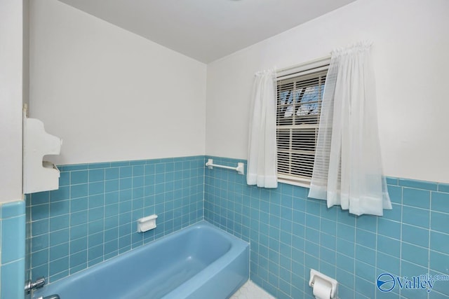 bathroom with a bath and tile walls