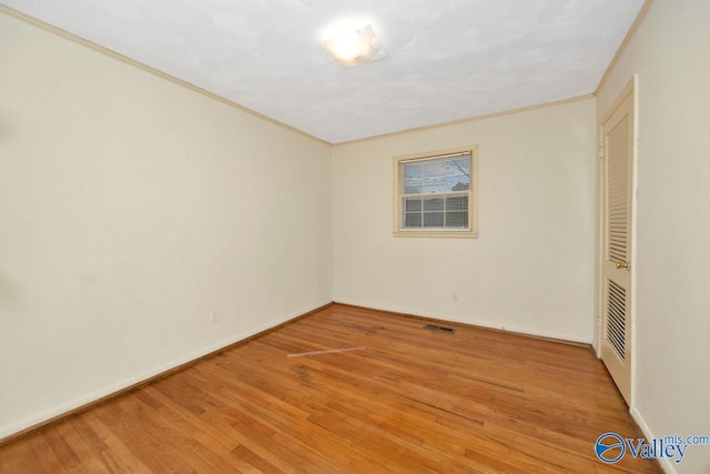 unfurnished room with crown molding and light hardwood / wood-style floors