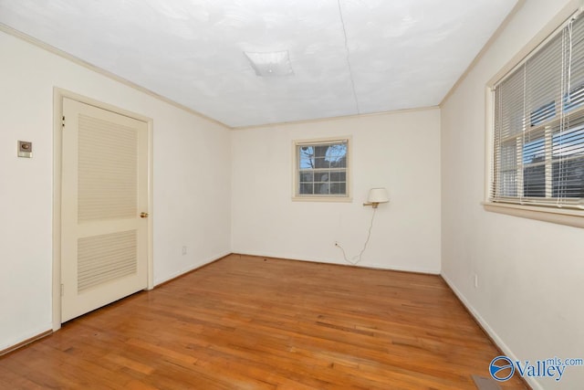 unfurnished room with crown molding and hardwood / wood-style flooring