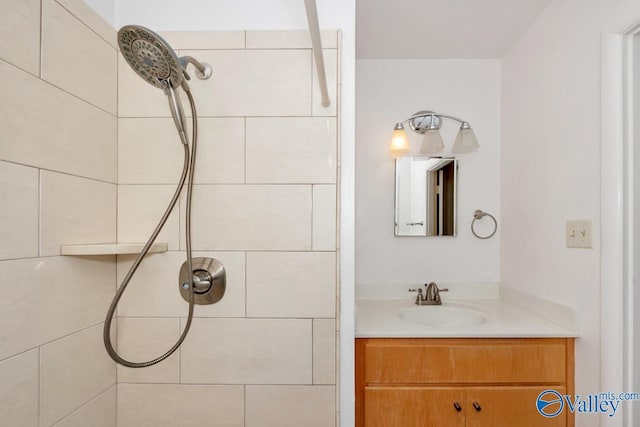 bathroom with a tile shower and vanity