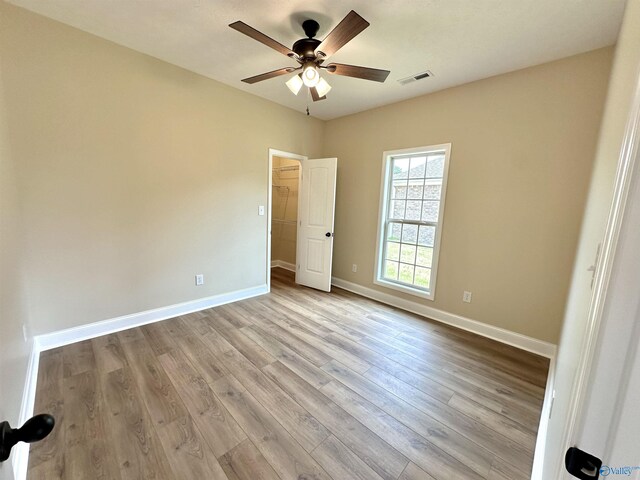 empty room featuring light wood-type flooring and ceiling fan