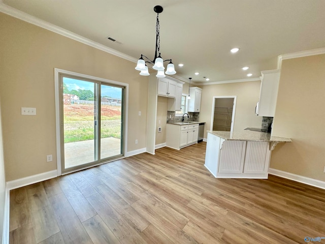 kitchen with white cabinetry, a kitchen bar, tasteful backsplash, light wood-type flooring, and kitchen peninsula