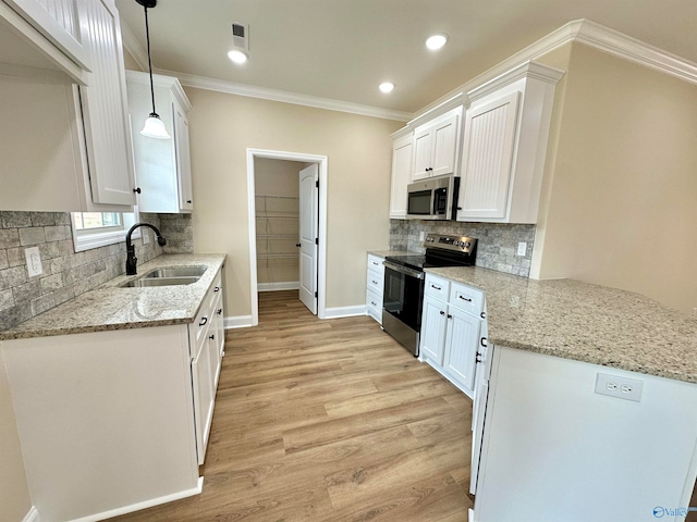 kitchen with appliances with stainless steel finishes, light hardwood / wood-style floors, sink, light stone counters, and pendant lighting