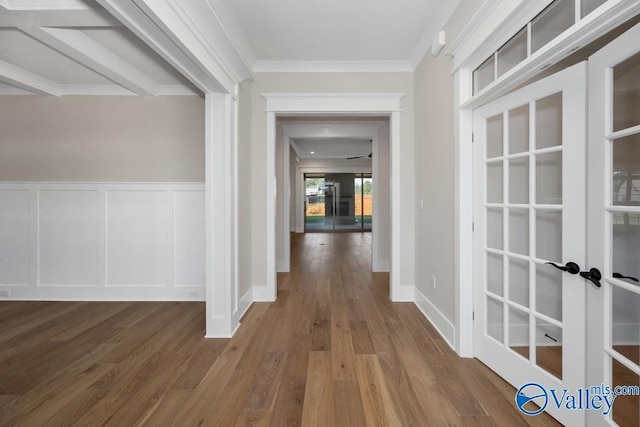 corridor featuring hardwood / wood-style flooring, ornamental molding, and french doors