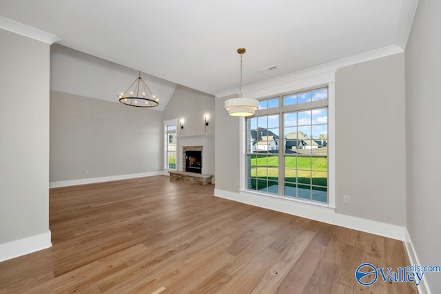 unfurnished living room with crown molding, wood-type flooring, a stone fireplace, and vaulted ceiling