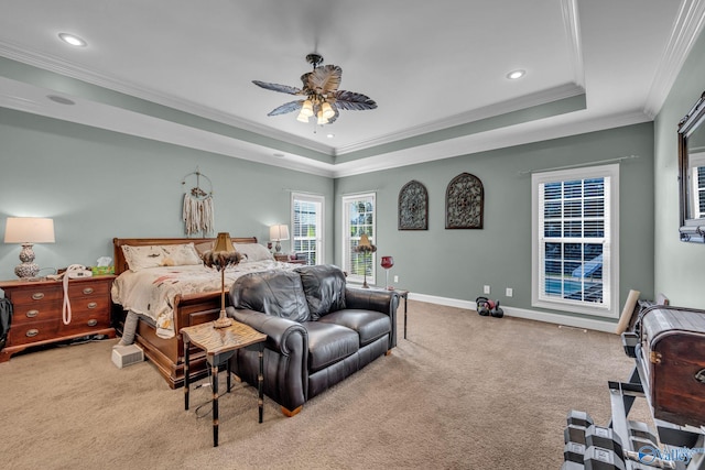 carpeted bedroom with ceiling fan, ornamental molding, and a tray ceiling