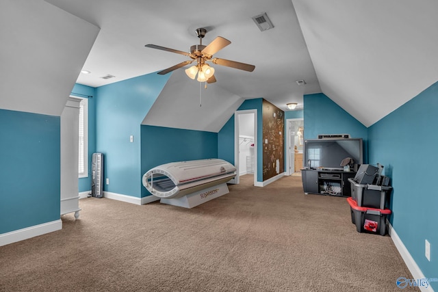 carpeted bedroom with ceiling fan, ensuite bathroom, and vaulted ceiling