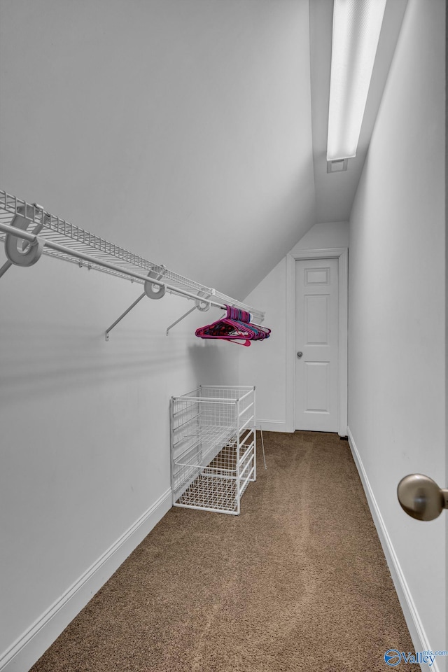 walk in closet featuring carpet flooring and vaulted ceiling